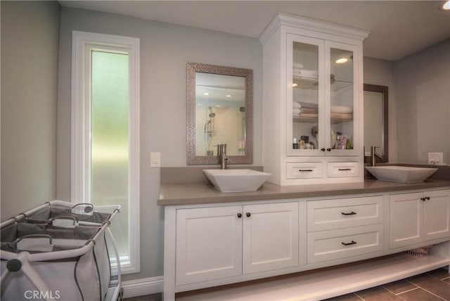 interior space featuring double vanity, a sink, and walk in shower