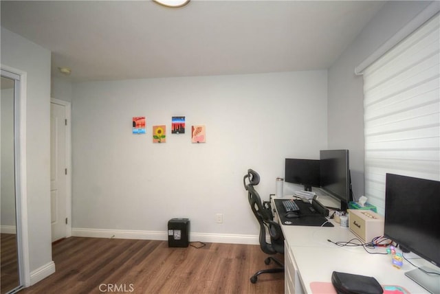home office with baseboards and wood finished floors