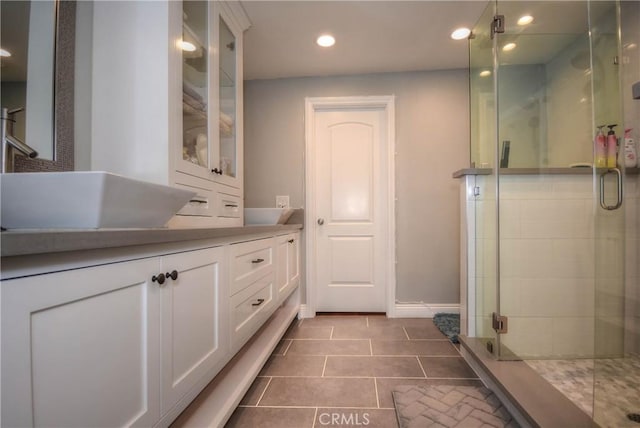 bathroom featuring a stall shower, vanity, tile patterned flooring, baseboards, and recessed lighting