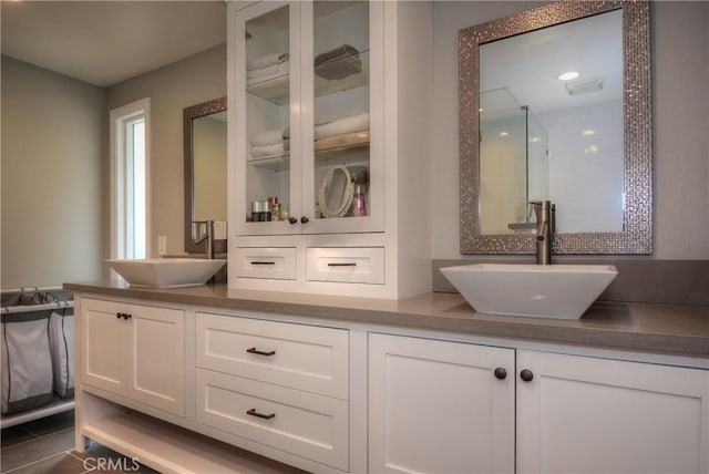 bathroom featuring double vanity, a sink, and tile patterned floors