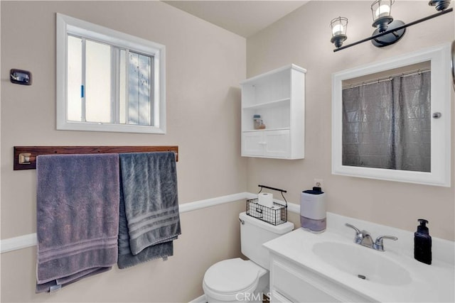 bathroom featuring curtained shower, toilet, and vanity