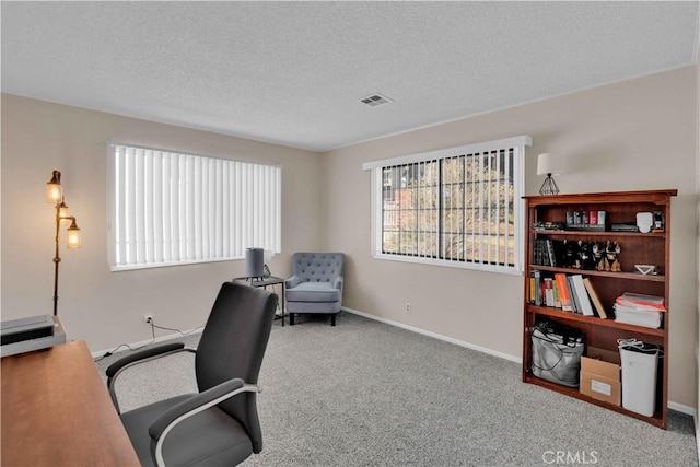 carpeted home office featuring baseboards, visible vents, and a textured ceiling