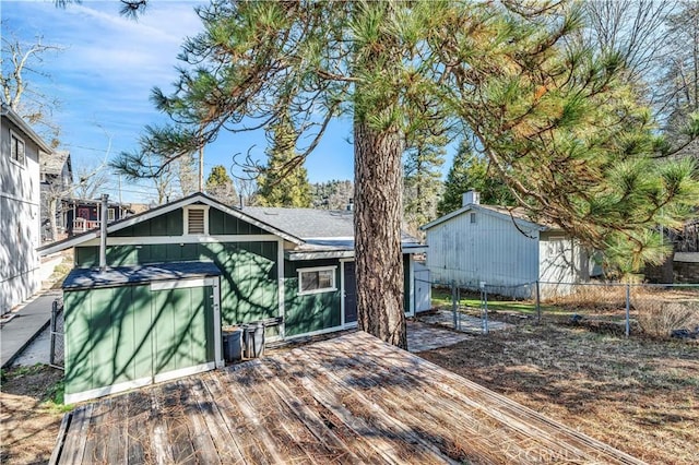 back of house featuring a deck and fence