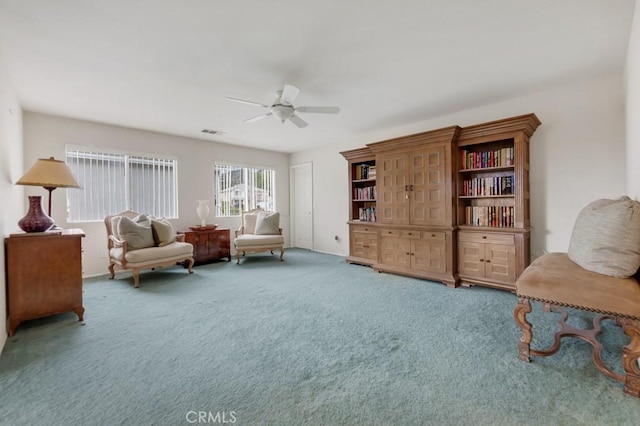 sitting room with carpet flooring, a ceiling fan, and visible vents