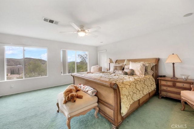 bedroom featuring visible vents, light colored carpet, and a ceiling fan