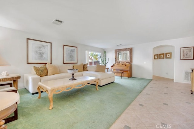 living area featuring light tile patterned floors, visible vents, and light carpet