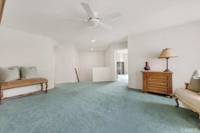 sitting room featuring carpet flooring, an upstairs landing, and ceiling fan