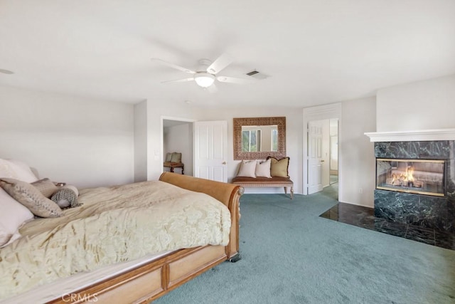 carpeted bedroom with visible vents, ceiling fan, and a high end fireplace