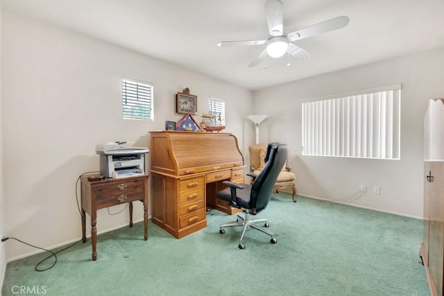 carpeted office space featuring baseboards and ceiling fan