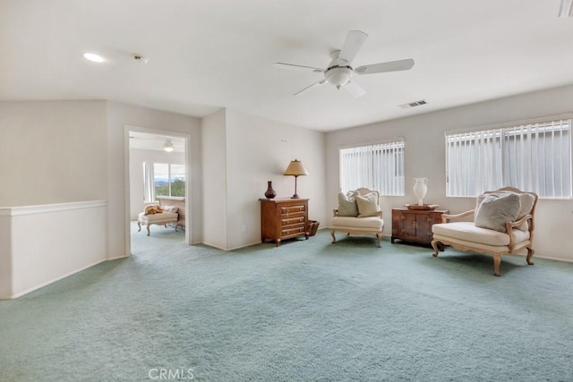 living area with carpet, a ceiling fan, and visible vents