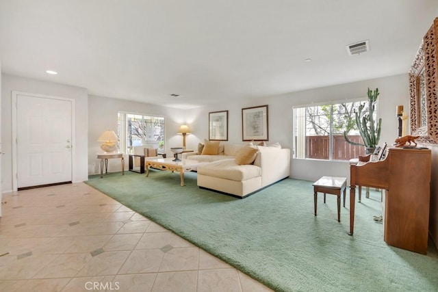 living room with visible vents, light colored carpet, a healthy amount of sunlight, and light tile patterned flooring