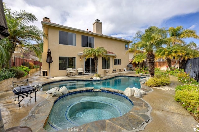 view of swimming pool with a patio, a fenced backyard, a pool with connected hot tub, and grilling area