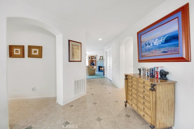 hall featuring visible vents, recessed lighting, arched walkways, light tile patterned flooring, and baseboards