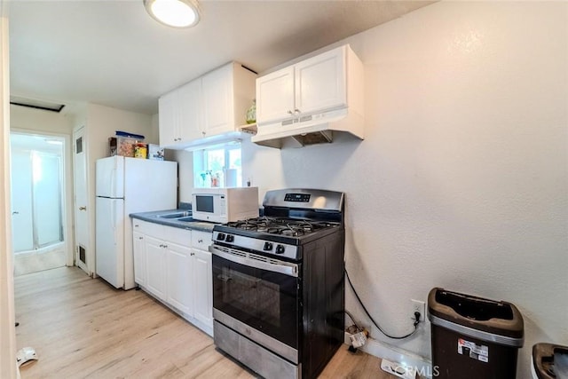 kitchen featuring white appliances, white cabinets, light wood finished floors, and under cabinet range hood