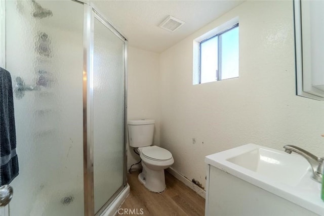 full bathroom with visible vents, a stall shower, toilet, and wood finished floors
