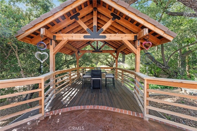 wooden terrace with outdoor dining space and a gazebo