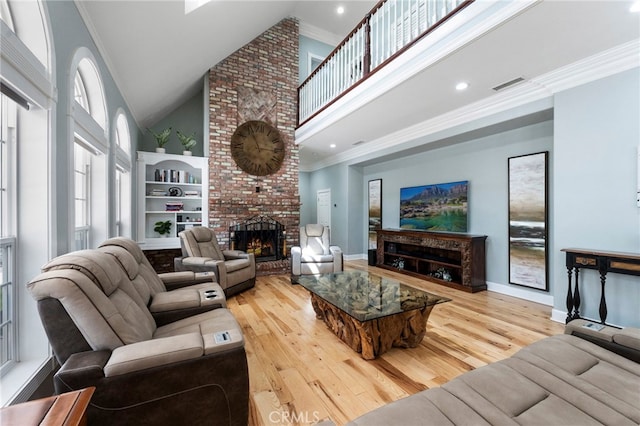 living area featuring crown molding, a high ceiling, wood finished floors, and visible vents