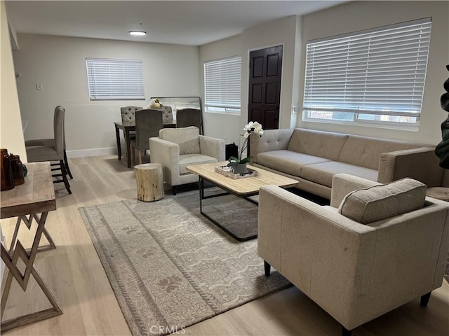 living area featuring light wood-type flooring and baseboards