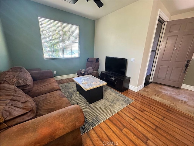 living area with ceiling fan, baseboards, and wood finished floors