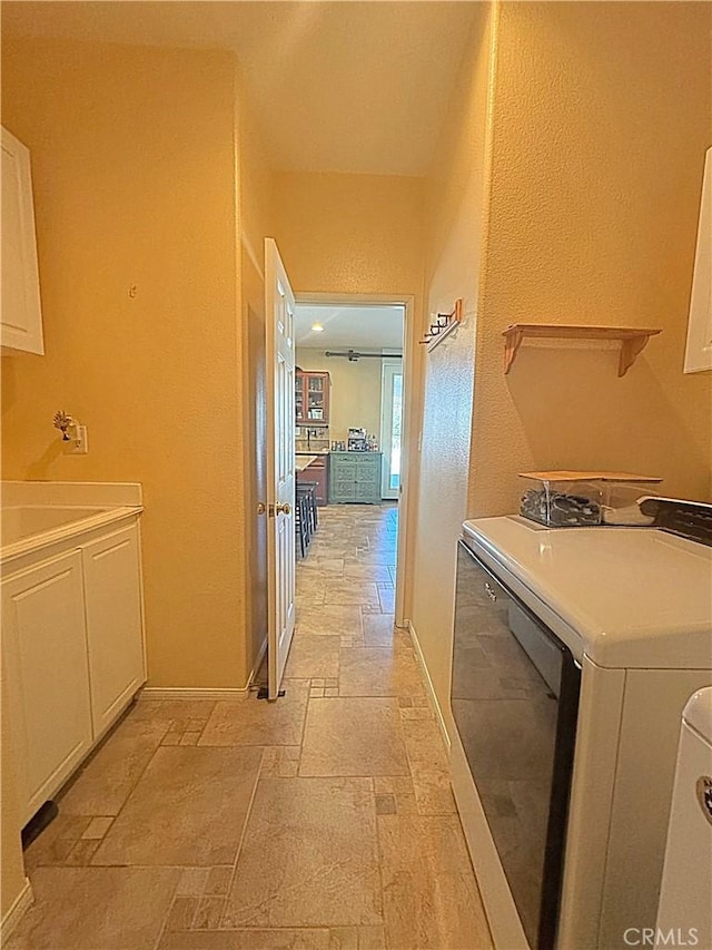 washroom with baseboards, cabinet space, and stone tile flooring