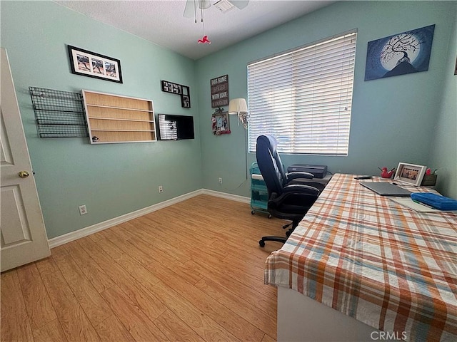 bedroom with a ceiling fan, baseboards, and wood finished floors