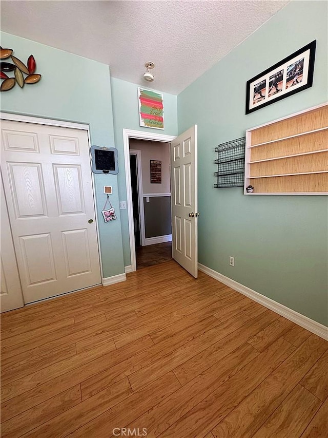 spare room featuring baseboards and light wood finished floors