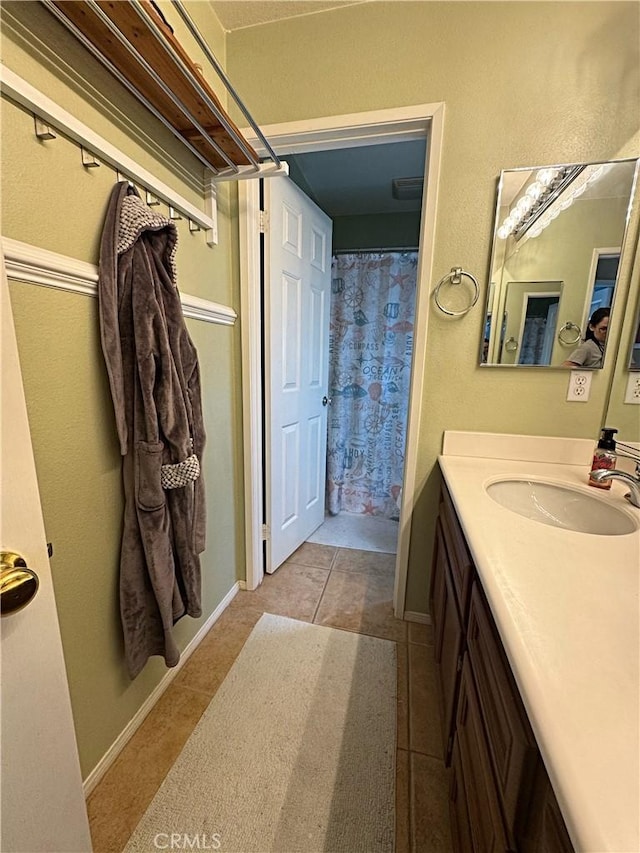 full bathroom with curtained shower, baseboards, vanity, and tile patterned flooring