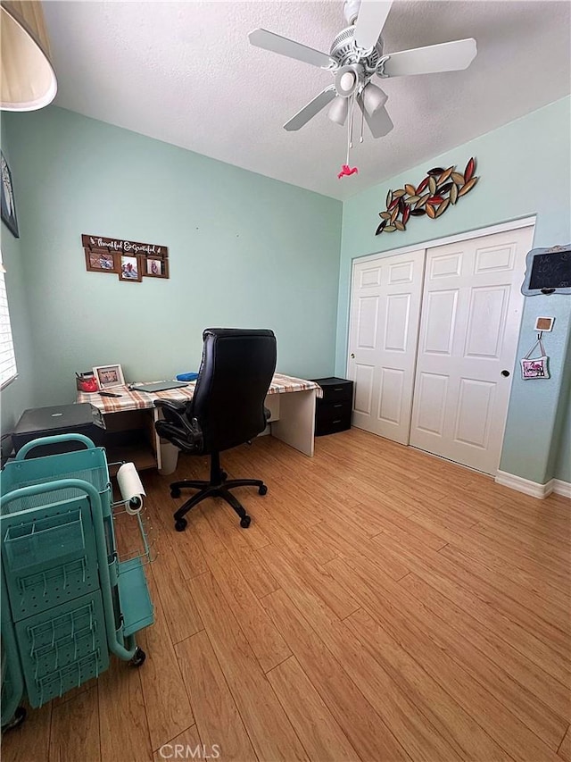 office area featuring light wood-type flooring, a textured ceiling, and a ceiling fan