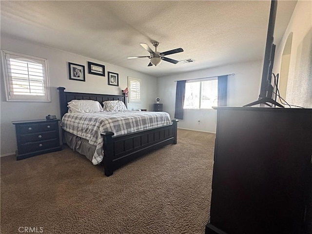 bedroom featuring visible vents, carpet, ceiling fan, and a textured ceiling