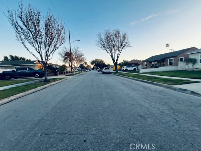 view of road with curbs, street lighting, and sidewalks