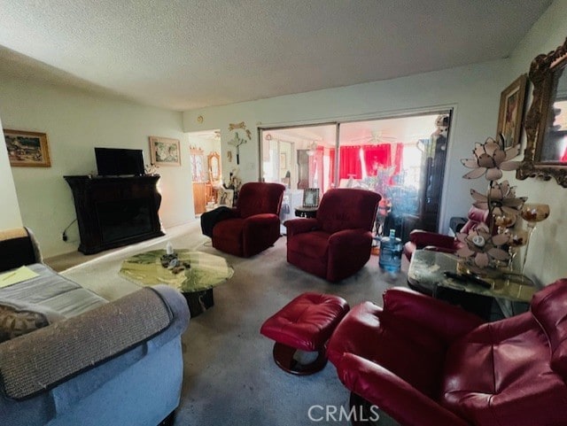 living room featuring carpet flooring, a fireplace, and a textured ceiling