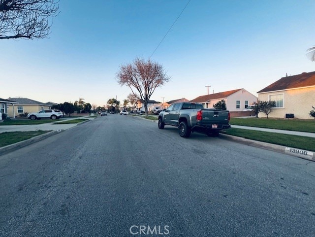 view of street with sidewalks, a residential view, and curbs