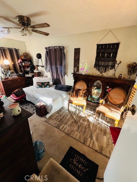 carpeted bedroom featuring a textured ceiling and a ceiling fan