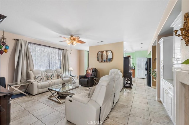 living room featuring light tile patterned floors, visible vents, and ceiling fan