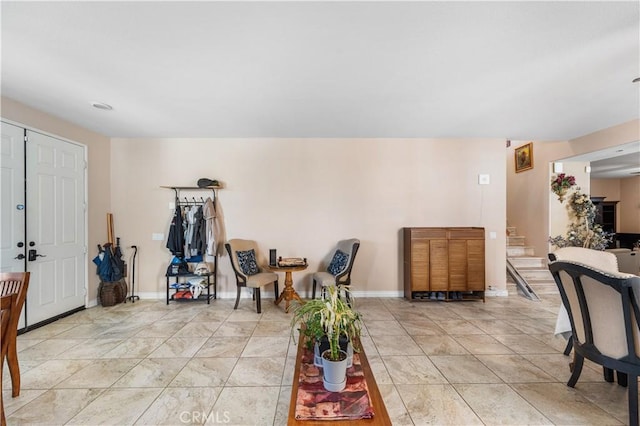 sitting room featuring stairway, light tile patterned flooring, and baseboards