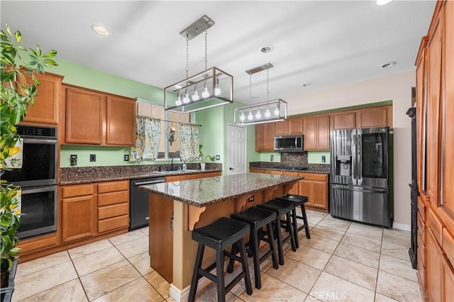 kitchen featuring a sink, light tile patterned floors, a kitchen island, and stainless steel appliances