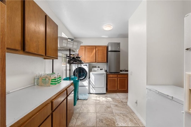 laundry room featuring a sink, light tile patterned flooring, cabinet space, and washer and clothes dryer