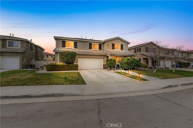 traditional home featuring stucco siding, a front lawn, concrete driveway, an attached garage, and a tiled roof