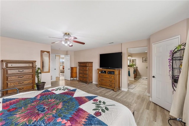 bedroom with visible vents, baseboards, ceiling fan, and light wood finished floors