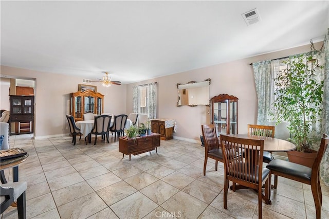 dining area featuring a ceiling fan, light tile patterned flooring, visible vents, and baseboards