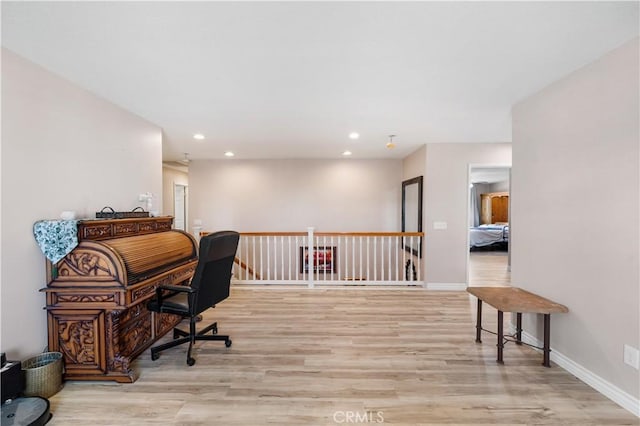 office space featuring recessed lighting, baseboards, and light wood-type flooring