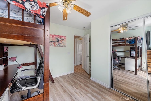 bedroom featuring ceiling fan, light wood-style floors, a closet, and baseboards