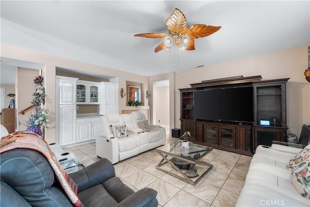 living room featuring light tile patterned floors, visible vents, and ceiling fan