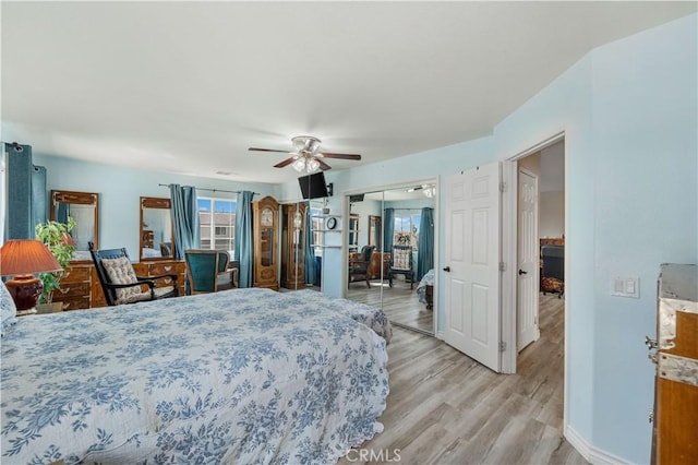 bedroom featuring baseboards, light wood finished floors, and ceiling fan