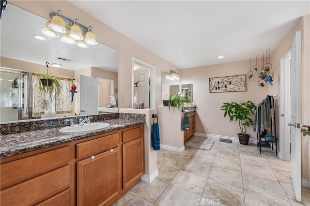 bathroom featuring a shower with door, visible vents, baseboards, and vanity