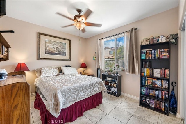 bedroom featuring light tile patterned floors, ceiling fan, and baseboards