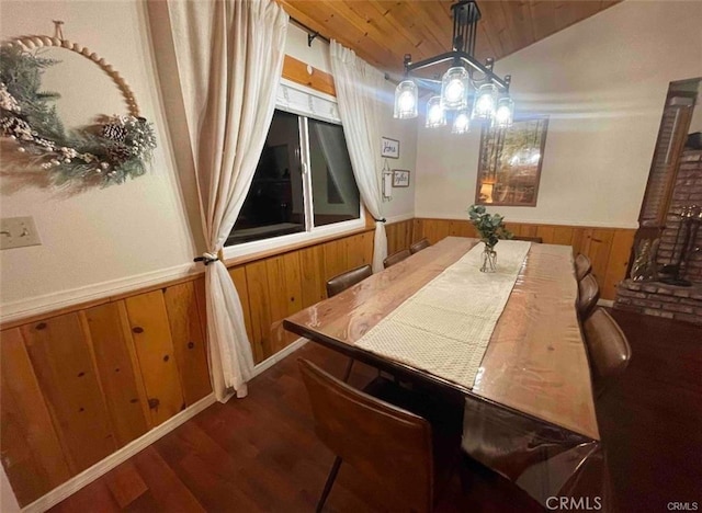 dining space featuring wood finished floors, a wainscoted wall, vaulted ceiling, wood ceiling, and wood walls