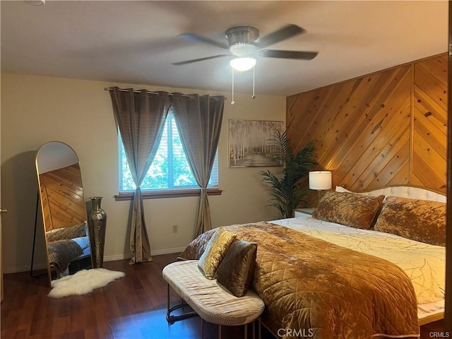 bedroom featuring wooden walls, ceiling fan, and wood finished floors