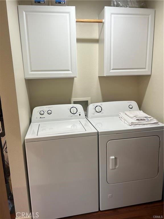 laundry room featuring cabinet space, separate washer and dryer, and dark wood-style flooring