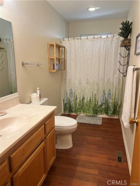 full bathroom featuring visible vents, toilet, a shower with curtain, wood finished floors, and vanity